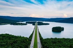 Gerade Straße führt über einen Fluss durch eine grüne saubere Natur.